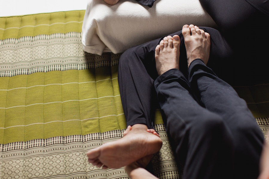 healer using massage with feet in side lying position